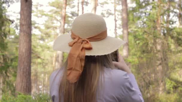 Atrakcyjna Kobieta Kapeluszem Robiąca Zdjęcia Filmy Pięknym Lasem — Wideo stockowe
