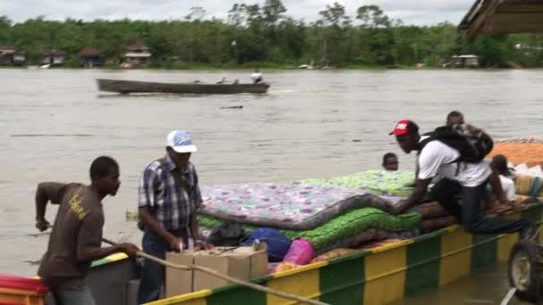 Ein Flussboot Mit Matratzen Und Menschen Die Vom Ufer Auf — Stockvideo