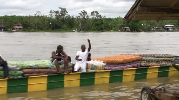 大きな川の上にマットレスを運ぶ幸せな男性と長い川のボート — ストック動画
