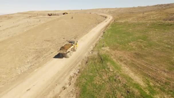 黄色的重型倾卸卡车将泥土运送上山 空中无人飞机俯瞰 — 图库视频影像