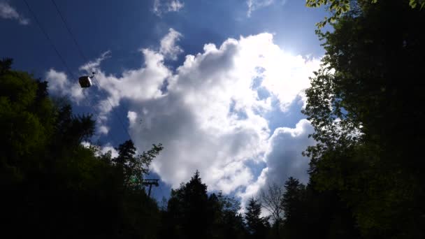 从下往上拍摄的缆车轮廓 在云层和蓝天的映衬下驶向山顶 — 图库视频影像