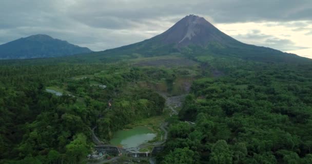 在印度尼西亚的Bego Pendem 空中向后飞行 展示了被印度尼西亚荒野包围的天然湖泊和背景巨大的Merapi火山 — 图库视频影像