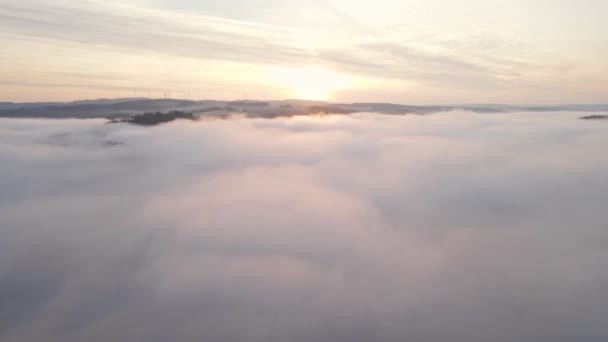 日の出には広大な深い谷を流れる厚い神秘的な朝の霧 空中広角パンニングショット — ストック動画