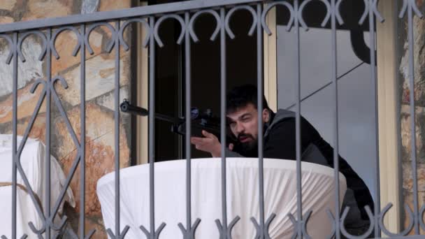 Scharfschütze Auf Dem Balkon Versteckt Hinter Einem Tisch Behutsam Auf — Stockvideo