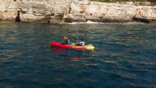 两名妇女在克罗地亚伊斯特利亚普拉斯悬崖和洞穴附近的波浪湖上划船 — 图库视频影像