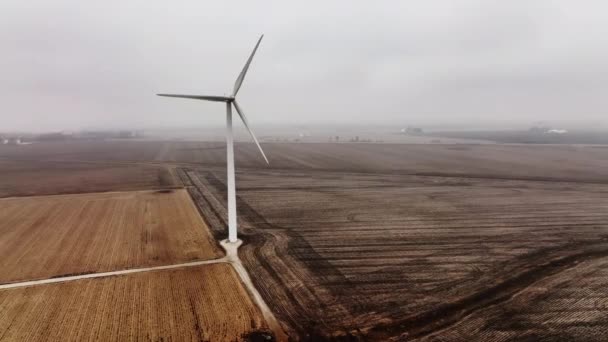 霧の多い農村環境でクリーンエネルギーを作成する風力タービンのドローンショット — ストック動画