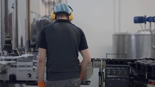 Rückenansicht Eines Bedieners Mit Haarnetz Und Kopfhörern Der Einer Bierfabrik — Stockvideo