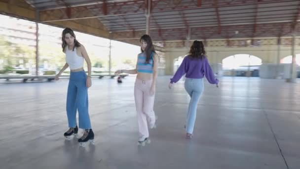 屋外で3人の女の子ローラースケートの追跡パン Slomo — ストック動画