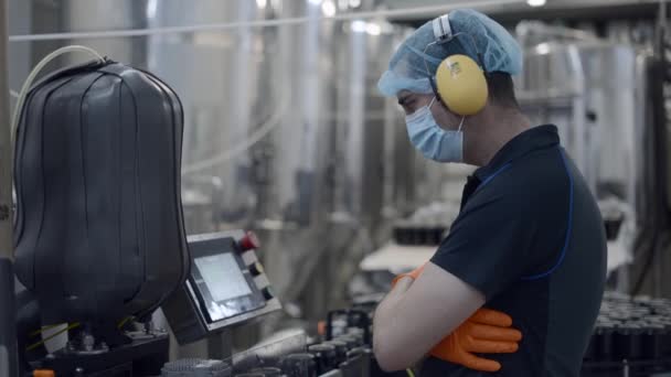 Fabrieksarbeider Operating Conveyor Met Beer Cans Moving Medium Shot — Stockvideo