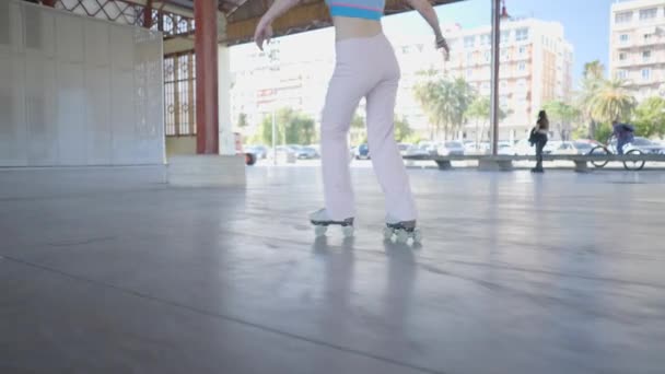 ピンクのパンツの女性の足ローラースケート屋外で 閉じるSlomoショット — ストック動画