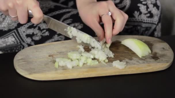 鋭いナイフで木製のまな板の上に玉ねぎをみじん切り女性の手 静的閉じる — ストック動画