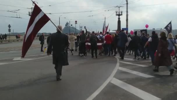 リガのソ連記念碑に対するラトビアの国旗と共に行進する人々 — ストック動画