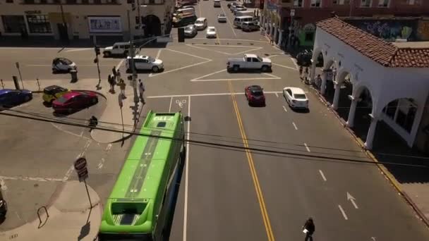 著名的威尼斯信件的标志 绿色巴士站 汽车驶过一个十字路口 伟大的航观飞行倾斜下降无人机镜头洛杉矶在威尼斯海滩美国2018年 菲利普 马尔尼茨的电影 — 图库视频影像