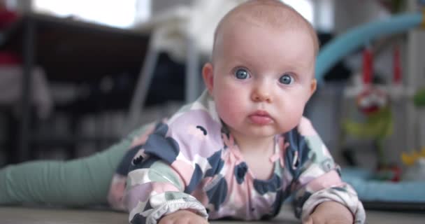 漂亮的蓝眼睛女婴在家里的地板上 — 图库视频影像