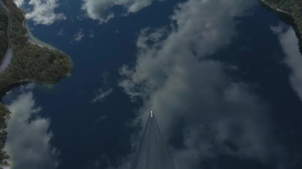 Човен Створює Брижі Дзеркалі Поверхня Води Озері Відображення Хмар Неба — стокове відео