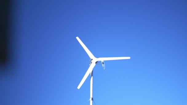 Biała Turbina Wiatrowa Obracająca Się Przeciwko Błękitnemu Niebu Ujawnia Strzał — Wideo stockowe