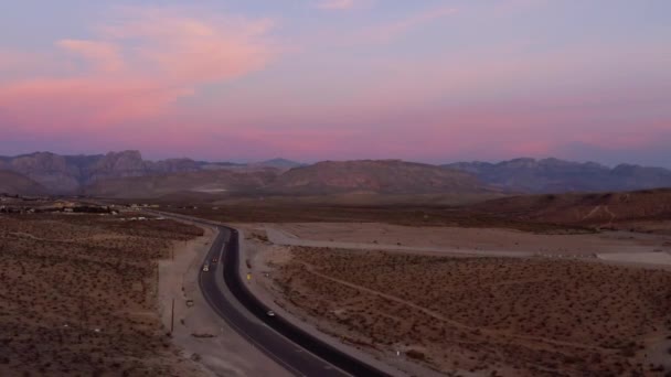 砂漠の道路上の車の空中ビュー カラフルな夜 アリゾナ州 ドリー ドローンショット — ストック動画