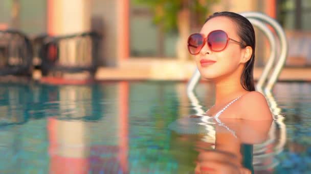 暑い夏の日に楽しむプールでのサングラスを持つ美しいセクシーなエキゾチックな女性 フルフレーム — ストック動画