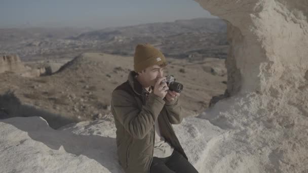 Genç Adam Çöldeki Bir Vadide Kayanın Üzerinde Oturuyor 35Mm Lik — Stok video