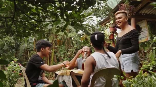 フィリピンの農村部にある家の外で 3人の男性とゲイの飲酒ウィスキーとチャット ショートフィルム ミディアムショット — ストック動画