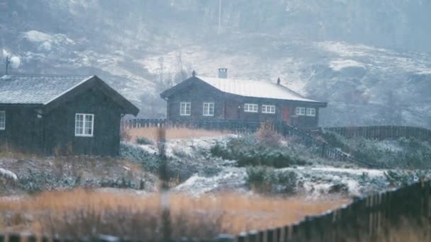 光の最初の雪は ノルウェーのボフトゥンにある木造キャビンの枯れた草 屋根に落ちます スローモーション — ストック動画