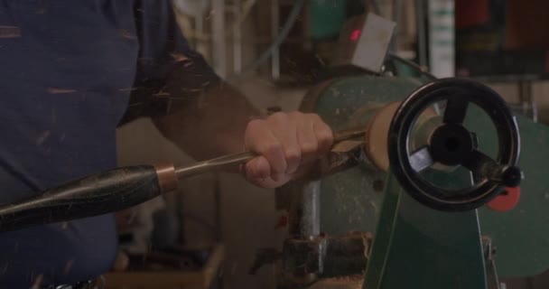 Ένας Άντρας Σκαλίζει Ένα Κομμάτι Ξύλο Έναν Πράσινο Ξύλινο Τόρνο — Αρχείο Βίντεο