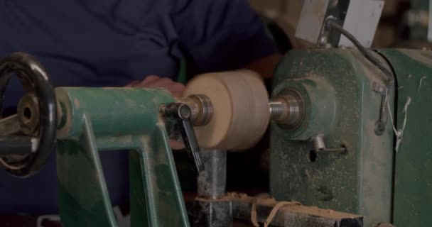 Ein Mann Schrägt Ein Stück Holz Auf Einer Grünen Holzdrehbank — Stockvideo