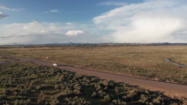 Белый Автомобиль Едет Широкой Открытой Дороге Через Пустую Сельскую Местность — стоковое видео