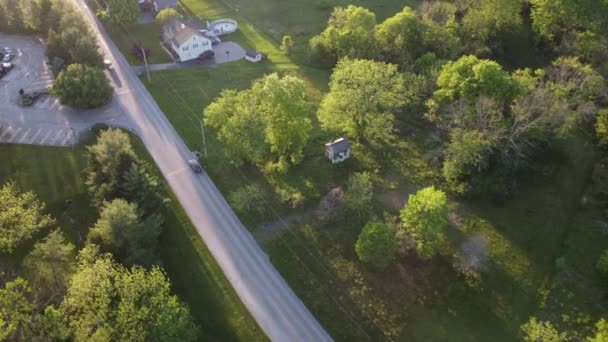 午後遅くの鳥の目の木や車で小さな町の道路上のビュー — ストック動画