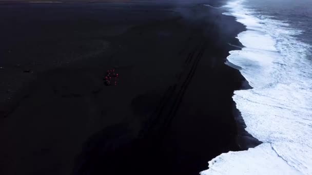 冰岛黑色沙滩上与海洋相邻的鲜红色四足摩托车的空中景观 — 图库视频影像
