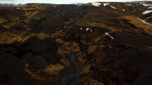 一条流经冰岛高地和火山黑色沙地的河流的空中景观 — 图库视频影像