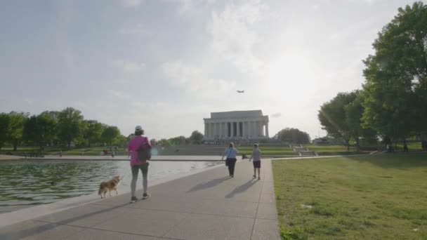 行人走过反光池边 身后是林肯纪念堂 — 图库视频影像