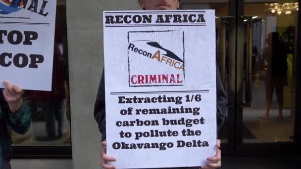 在非洲能源峰会期间 一名气候变化抗议者在Mayfair酒店外高举标语牌 称Recon Africa能源公司有罪 — 图库视频影像