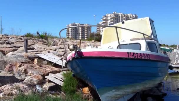 Old Motorboat Tied Rocky Shoreline Aerial Ascent View Apartments Condos — Vídeos de Stock