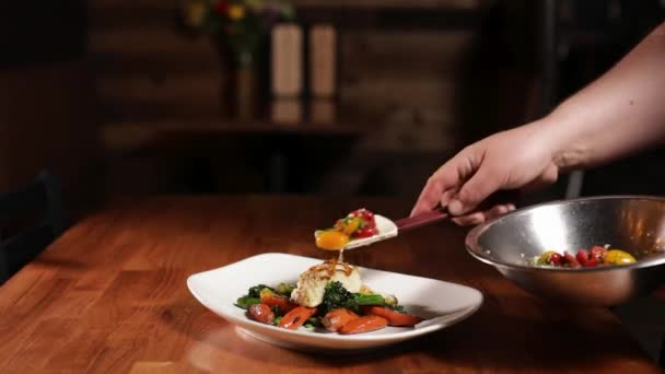 Chef Setzt Sautierte Tomaten Mit Kräutern Auf Gegrillten Heilbutt Aus — Stockvideo