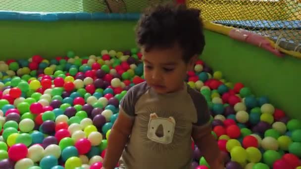 Uma Criança Jovem Brincando Com Bolas Coloridas Divertindo Uma Sala — Vídeo de Stock