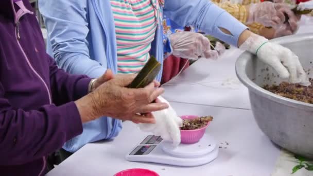 台所で葉の中に包まれる紫色の米と肉の混合物を測定し 準備する忙しいキッチン労働者の手 — ストック動画