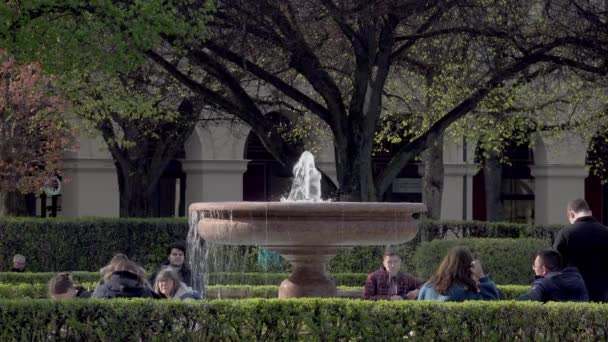 在德国巴伐利亚慕尼黑的Hofgarten 人们围坐在喷泉旁 享受着一个美好的春日 — 图库视频影像