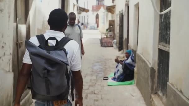 黒男リュックの狭い石の町の通り Zanzibarで歩いて — ストック動画