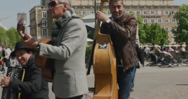 Drie Straatmuzikanten Praten Met Voorbijgangers Bespelen Instrumenten Het Centrum Van — Stockvideo