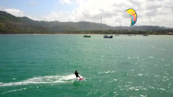 Junger Mann Beim Kitesurfen Und Winkt Vergnügt Die Kamera Luftaufnahmen — Stockvideo