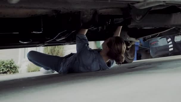 20代前半の女性はトラックのフードの下でチェックし 機械的な問題を見つけて修正するためにトラックの下に行く Fps — ストック動画
