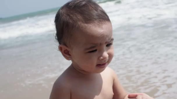 妈妈试图把她吓坏了的女婴的手放在海滨 — 图库视频影像