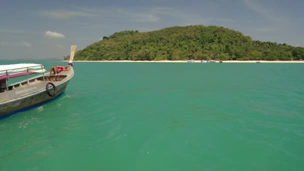无人机跟着一个穿着红色比基尼的女孩在一条长尾船上向一个岛屿飞去 — 图库视频影像