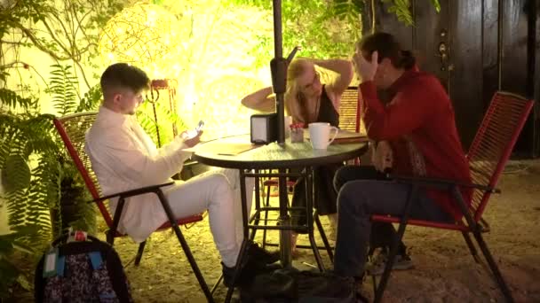 Mature Couple Looks Menu While Teen Son Takes Selfies Outdoor — Video Stock