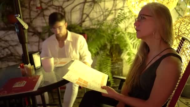 Güzel Bir Kadının Konuşmasına Menüye Bakmasına Bir Kafede Genç Bir — Stok video