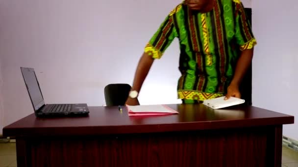 一个非洲商人走上台来 坐下来欢迎他的客户 问他能帮什么忙 — 图库视频影像