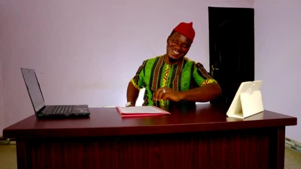 在他的办公室里愉快地摆出尼日利亚商人的架势 — 图库视频影像