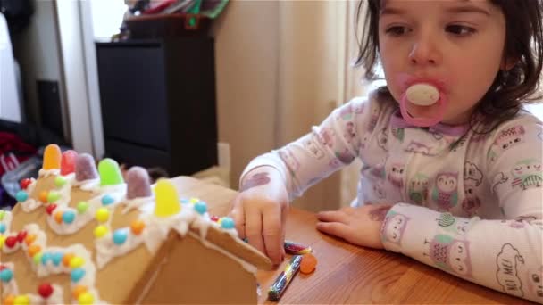 Menina Jovem Adiciona Pequenos Doces Coloridos Para Uma Casa Gengibre — Vídeo de Stock