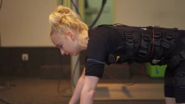 Pan Right Young Lady Performs Pushups While Connected Ems Training — Video Stock